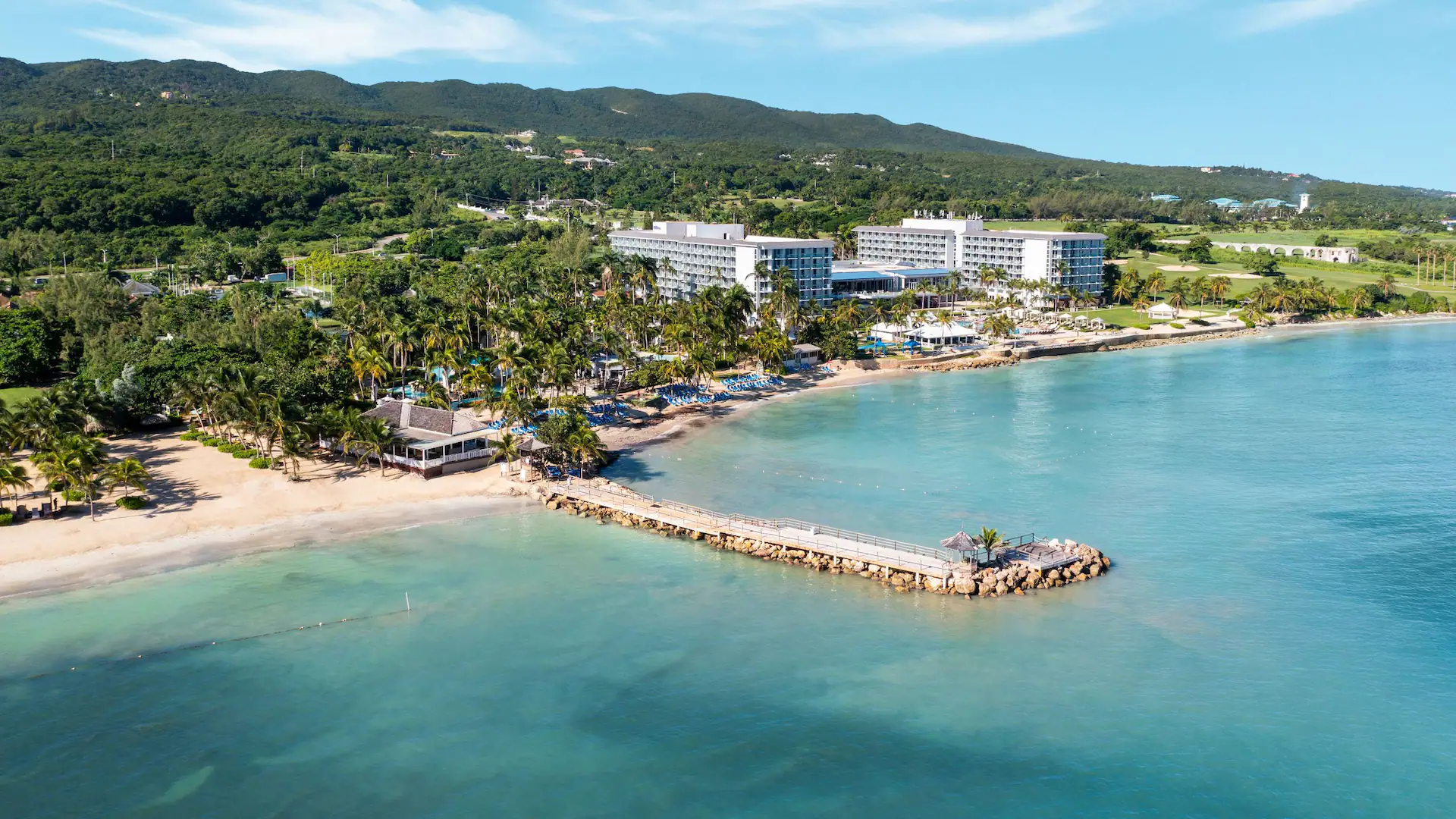 Aerial beachfront view of Dreams Rose Hall Resort & Spa with turquoise Caribbean waters and tropical palm-lined beaches in Montego Bay.