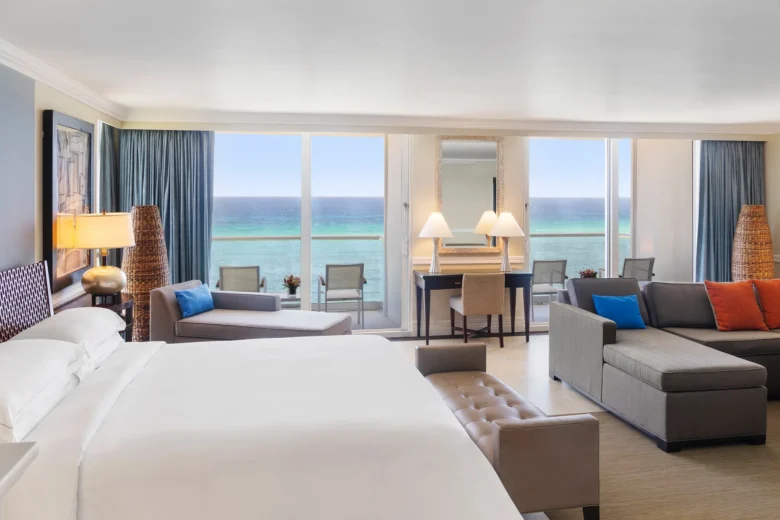 Oceanfront Prime Minister Suite king bedroom with panoramic Caribbean Sea views at Dreams Rose Hall Resort & Spa.