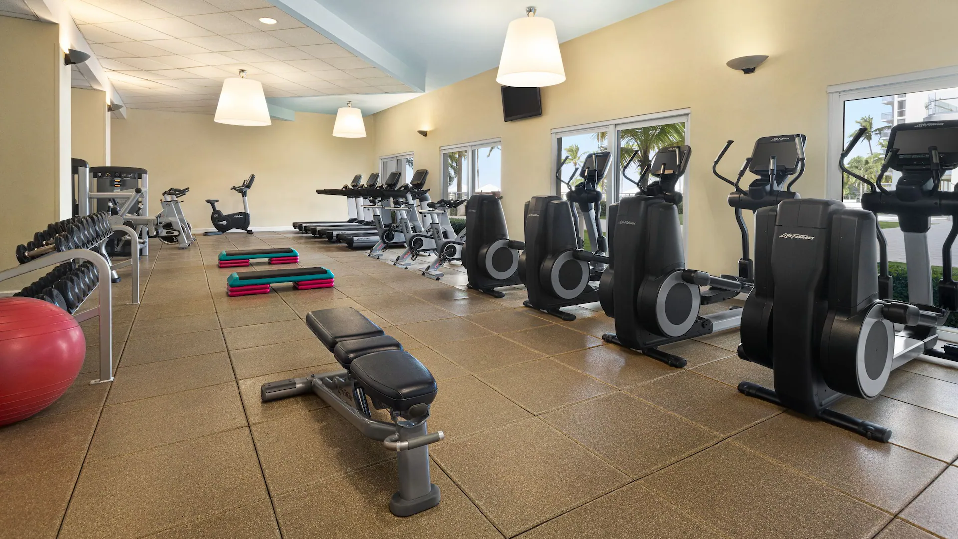 Modern fitness center with cardio machines and workout equipment at Dreams Rose Hall Resort & Spa in Montego Bay.