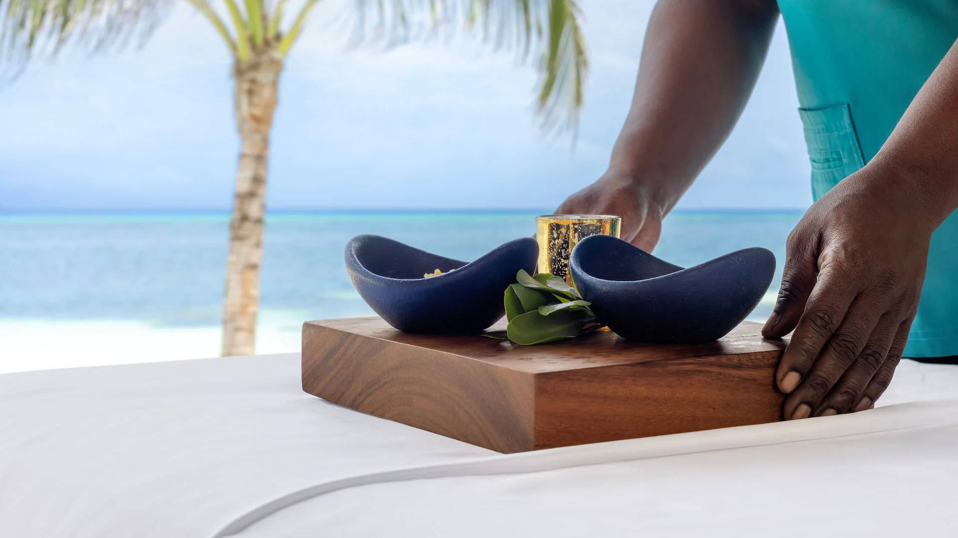 Spa amenities arranged beside the beach at Dreams Rose Hall Resort & Spa, showcasing a relaxing oceanfront wellness experience in Jamaica.