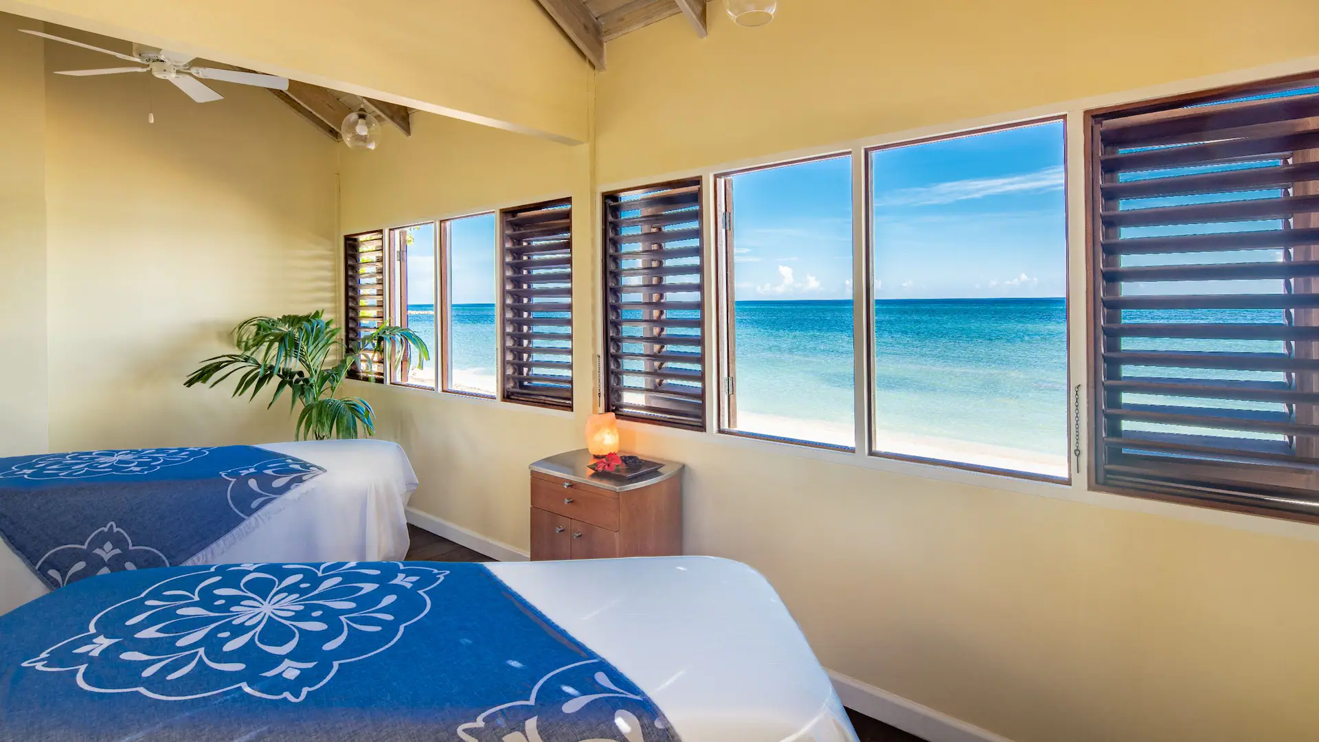 Oceanfront spa treatment room with massage tables and Caribbean Sea views at Dreams Rose Hall Resort & Spa in Jamaica.