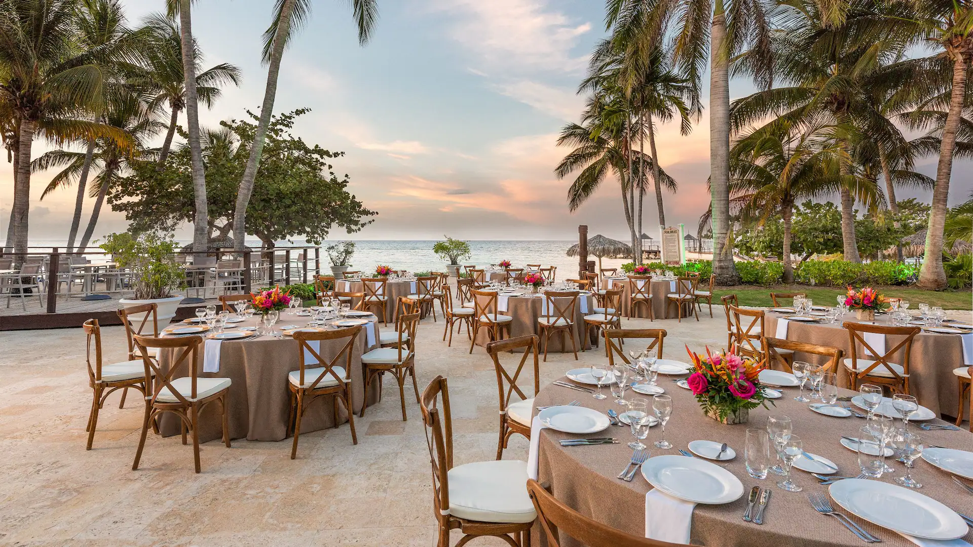 Outdoor wedding reception setup with elegant dining tables at Dreams Rose Hall Resort & Spa in Jamaica.