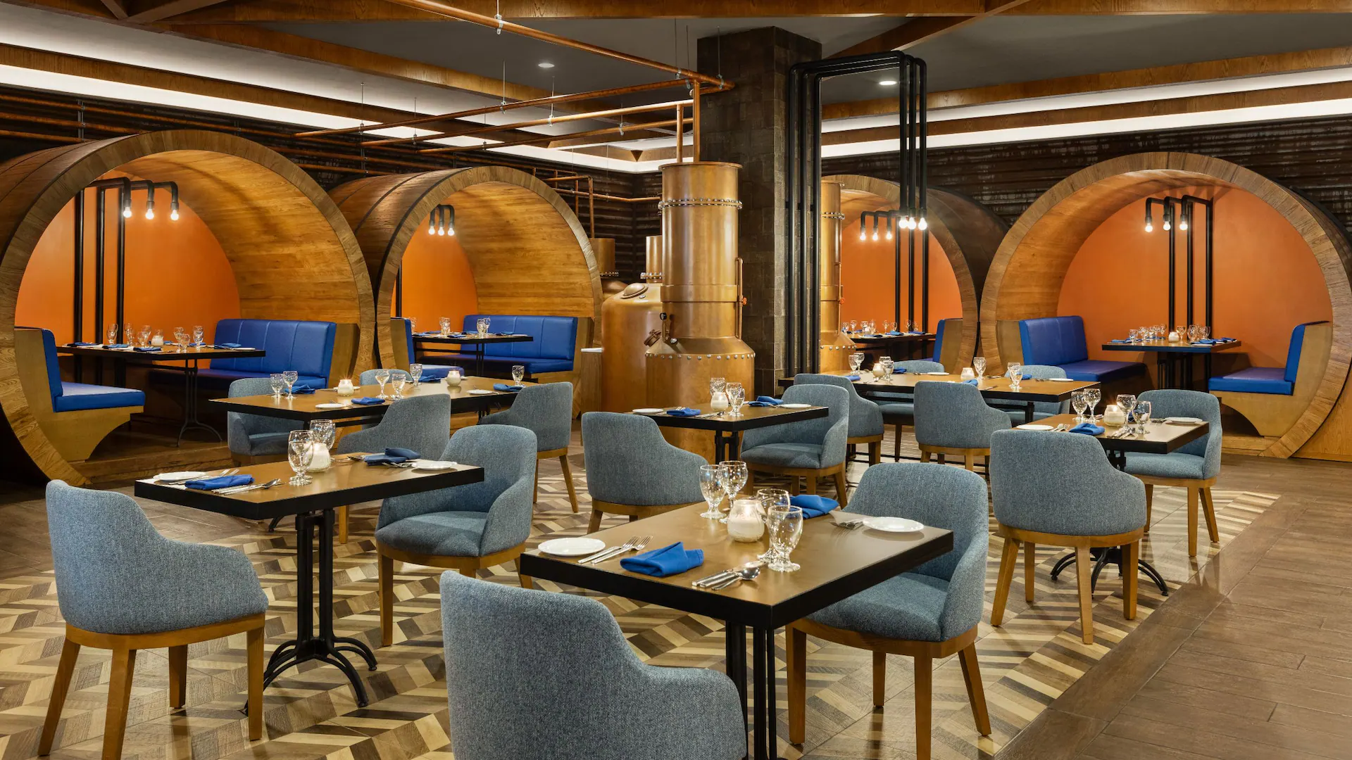 Stylish Rum Factory restaurant interior at Dreams Rose Hall Resort & Spa featuring barrel-inspired seating and upscale Caribbean dining.