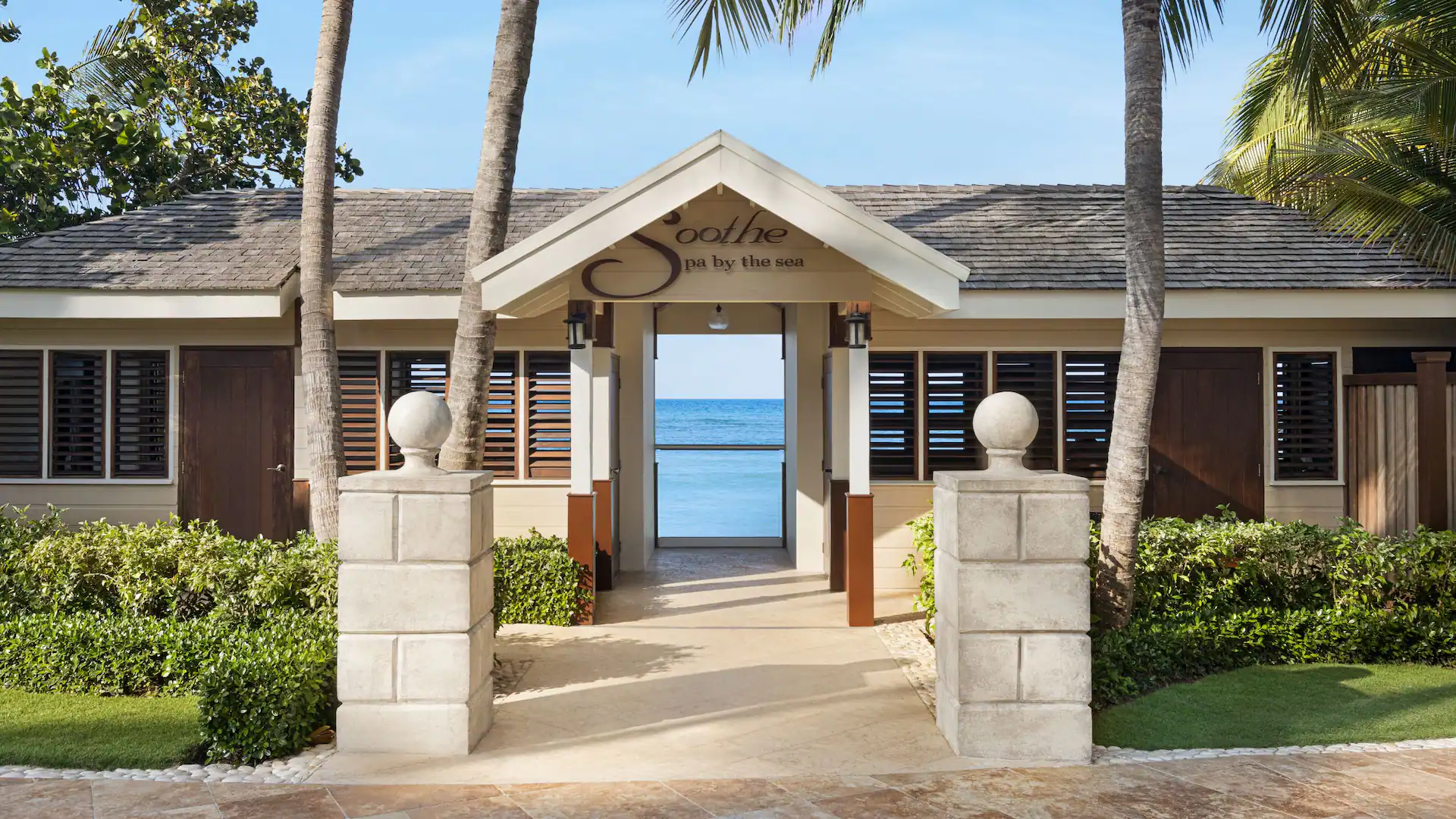 Exterior entrance to the Soothe Spa by the Sea at Dreams Rose Hall Resort & Spa overlooking the Caribbean coastline in Jamaica.