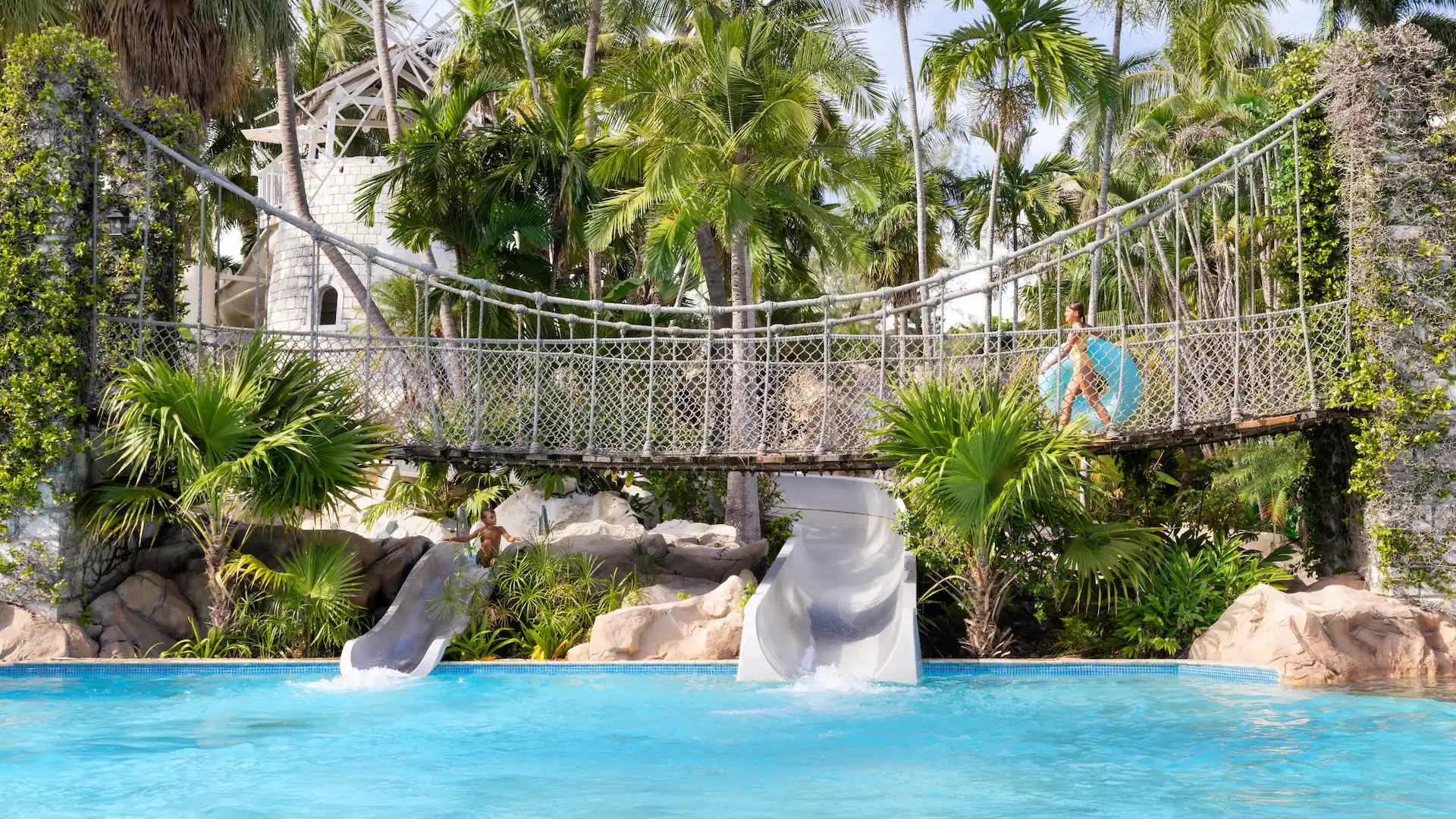 Children enjoying waterslides and tropical pool attractions at Dreams Rose Hall Resort & Spa in Montego Bay, Jamaica.